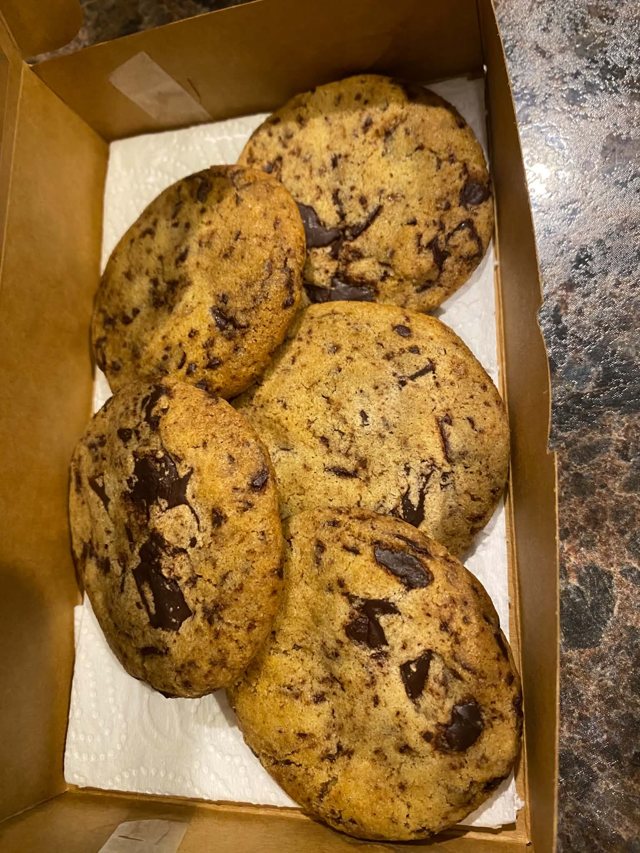 Cookies with chocolate pieces arranged in a parchment-lined box.
